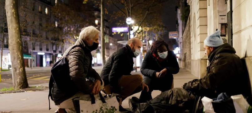 Maraude : 3 personnes s'adressant à un SDF dans la rue
