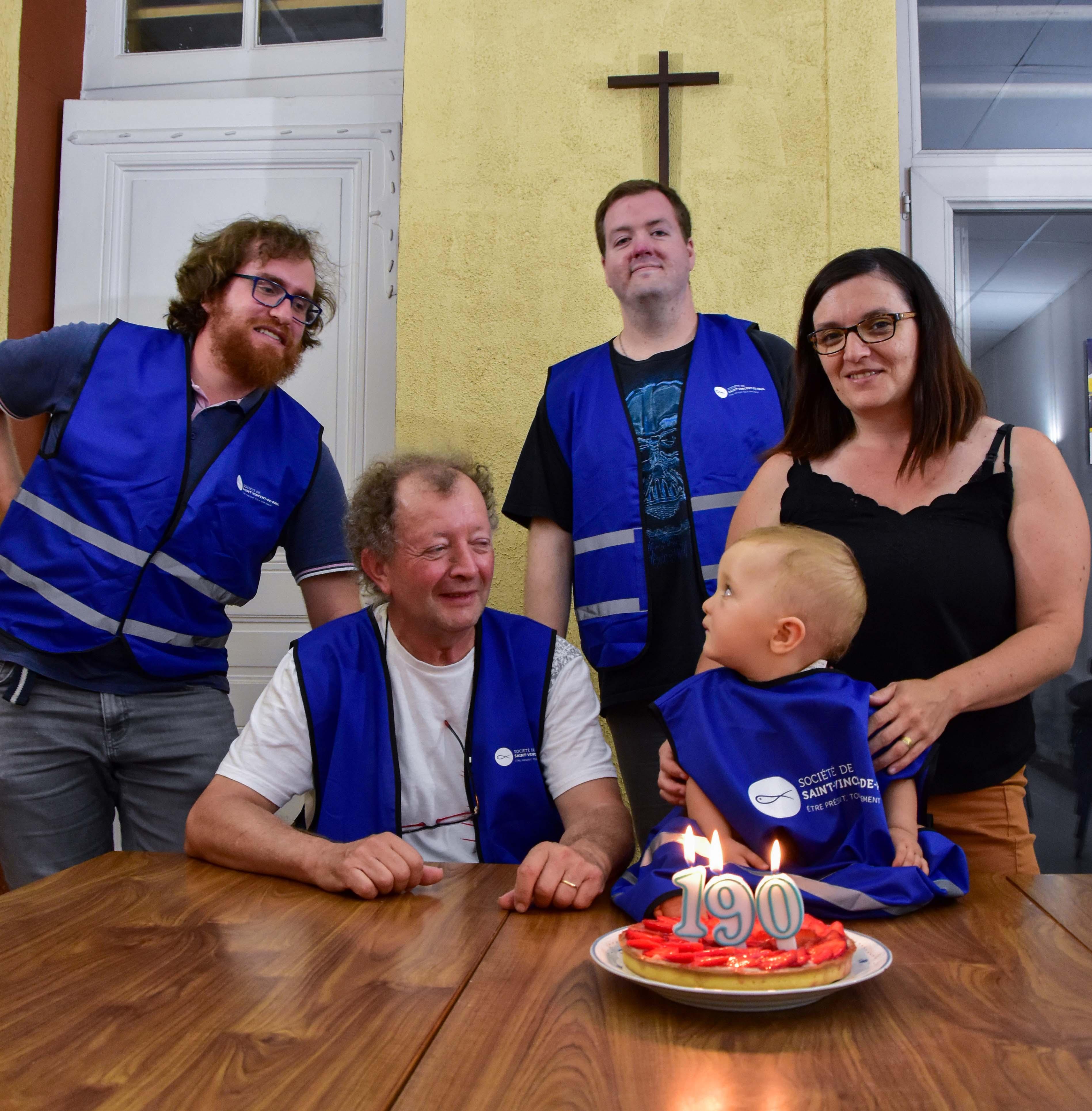 Groupe de personnes autour d'un gateau