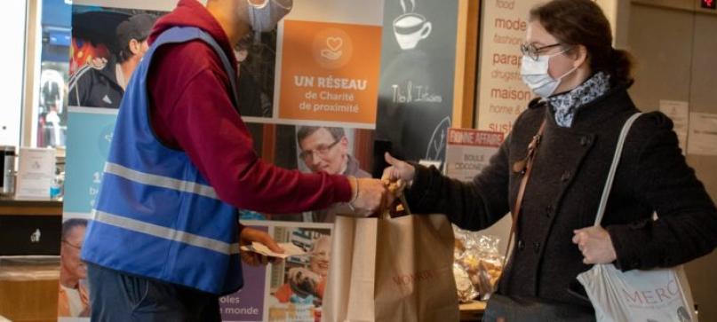 Un bénévole avec une femme en situation de précarité. Un bénévole avec une femme en situation de précarité.
